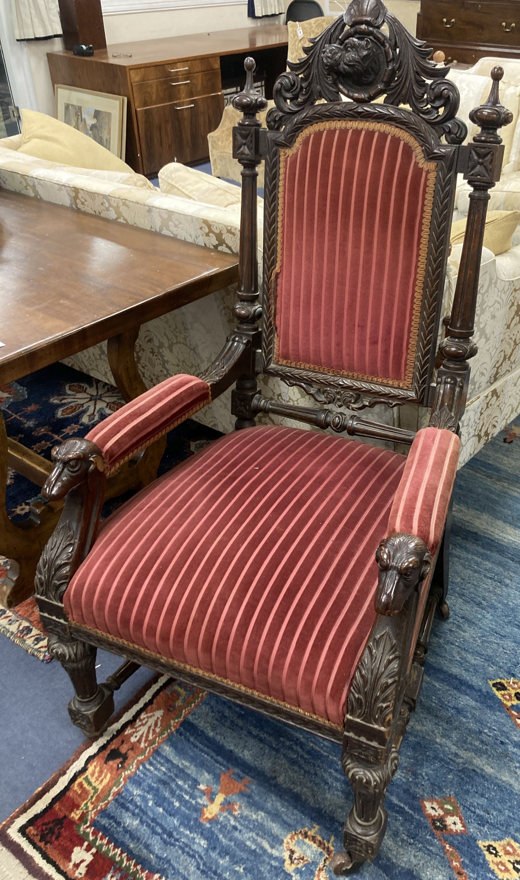 A late 19th century oak Carolean style armchair, with carved dogs head arms, width 68cm, depth 66cm, height 130cm